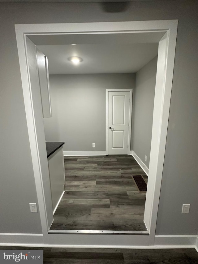 hallway with dark hardwood / wood-style floors