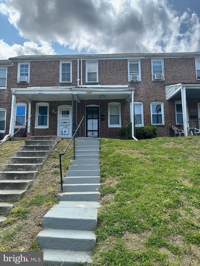 townhome / multi-family property with a front yard