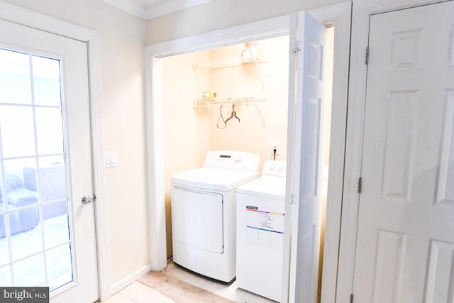 laundry room featuring washing machine and dryer and light tile patterned flooring