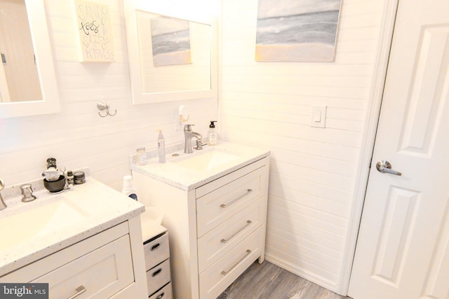 bathroom with wood-type flooring, vanity, and wood walls