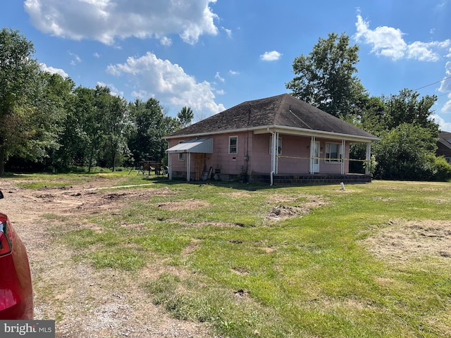 view of property exterior with a porch and a yard