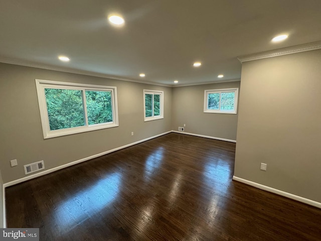 empty room with ornamental molding and dark hardwood / wood-style floors