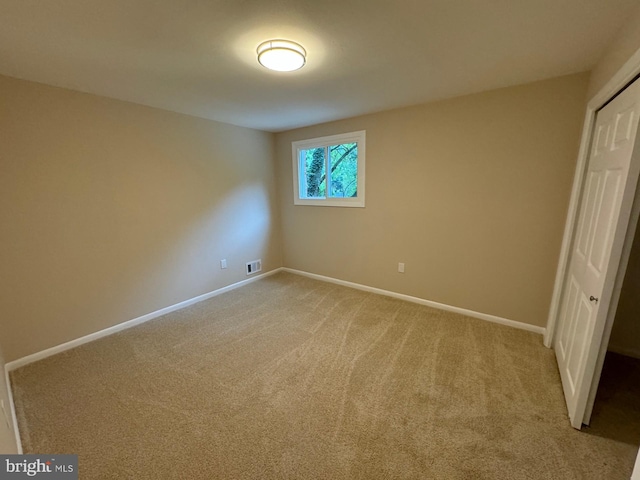 unfurnished bedroom with light carpet and a closet