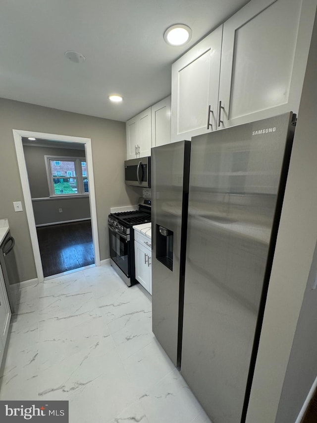 kitchen featuring white cabinets, stainless steel appliances, and light hardwood / wood-style flooring