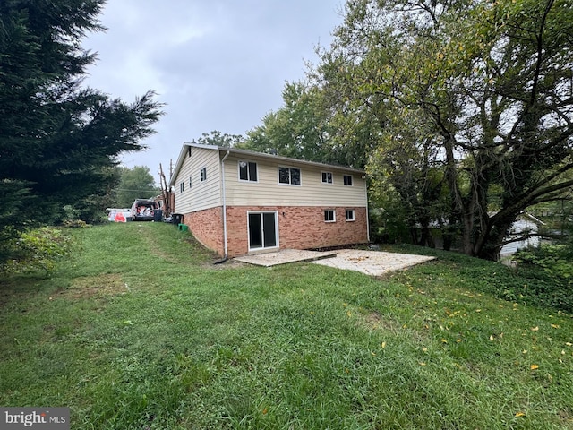 back of house with a patio and a yard