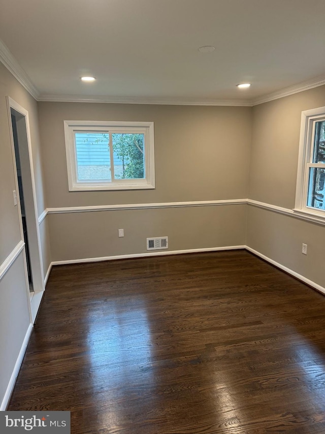 spare room with ornamental molding and dark hardwood / wood-style floors