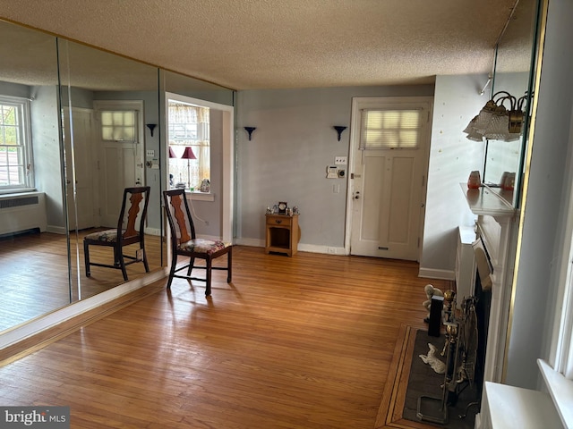 foyer with a textured ceiling, radiator, and hardwood / wood-style floors