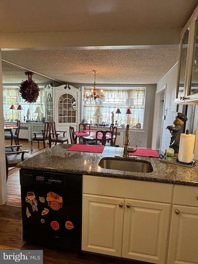 kitchen with a textured ceiling, dark wood-type flooring, sink, a notable chandelier, and white cabinetry