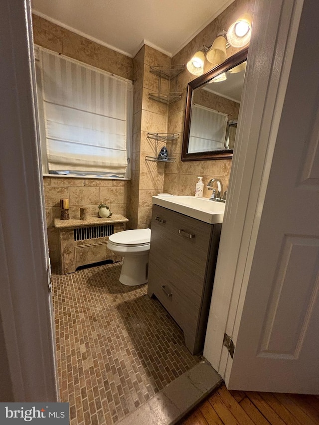 bathroom featuring tile walls, wood-type flooring, a shower, vanity, and toilet