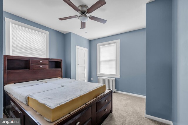 carpeted bedroom with radiator heating unit and ceiling fan