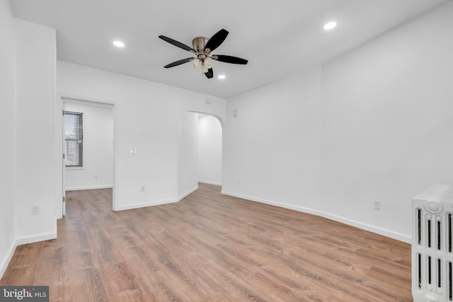 empty room with ceiling fan and light hardwood / wood-style floors