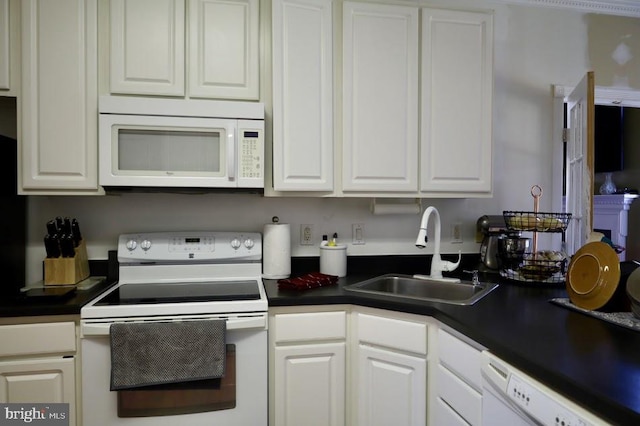 kitchen with white appliances, sink, and white cabinetry