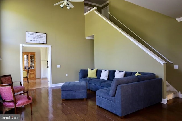 living room with dark hardwood / wood-style floors, a high ceiling, and ceiling fan