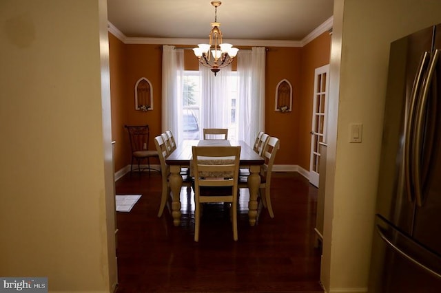 dining area featuring dark hardwood / wood-style floors, crown molding, and an inviting chandelier