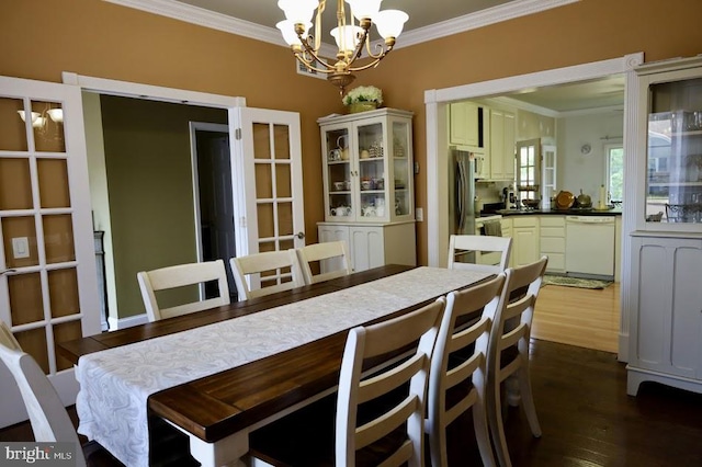 dining space with an inviting chandelier, dark hardwood / wood-style floors, and crown molding