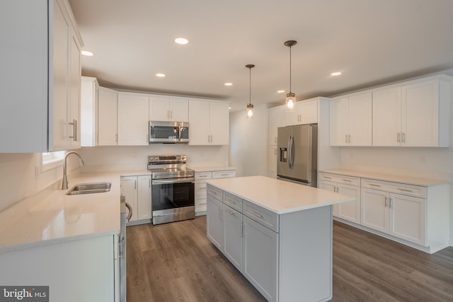 kitchen with stainless steel appliances, a center island, sink, and white cabinetry