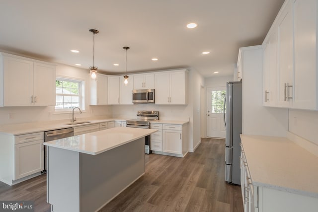 kitchen with appliances with stainless steel finishes, dark hardwood / wood-style flooring, sink, and white cabinets