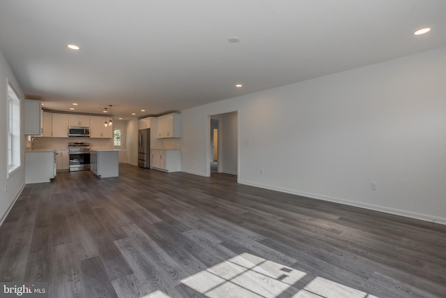 unfurnished living room with sink and dark hardwood / wood-style flooring