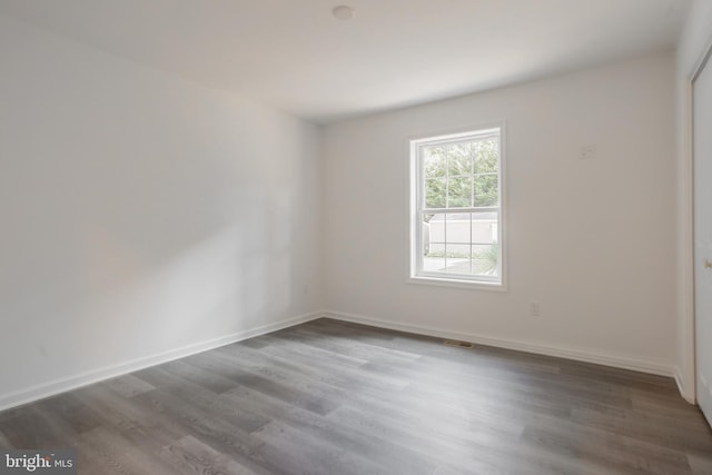 spare room with dark wood-type flooring