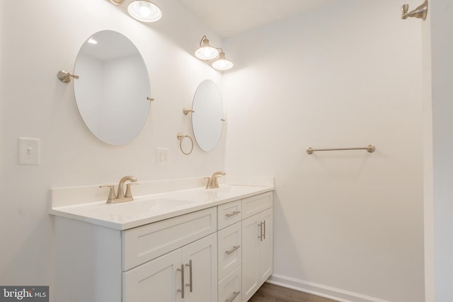 34709 Bowman Ln, Frankford, DE 19945 - bathroom featuring double vanity, wood finished floors, and baseboards