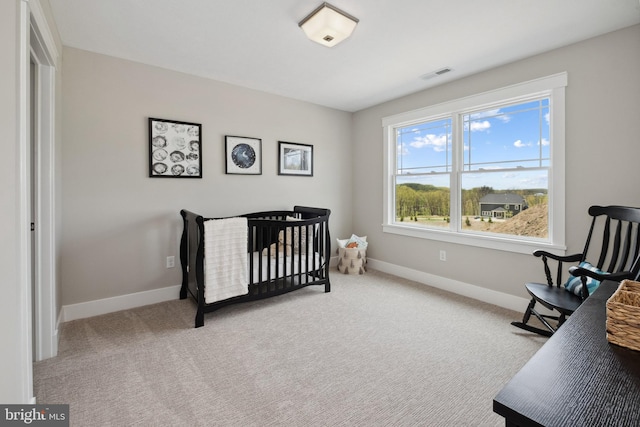 carpeted bedroom with a nursery area