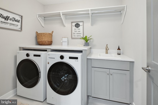 clothes washing area with washing machine and dryer, sink, and light tile patterned floors