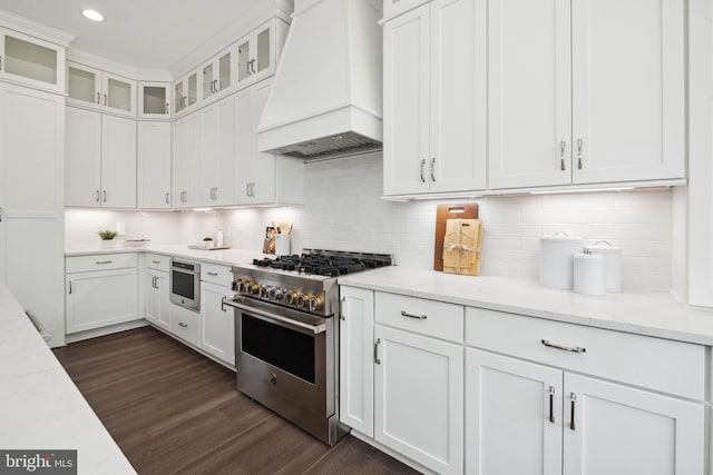 kitchen featuring custom range hood, white cabinetry, light stone countertops, and stainless steel appliances