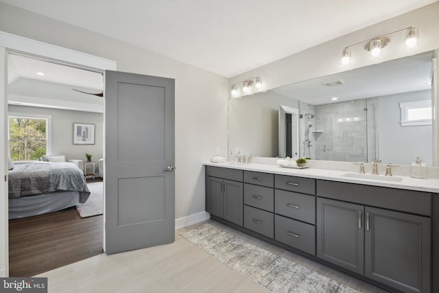 bathroom featuring vanity, hardwood / wood-style floors, vaulted ceiling, and a shower with door