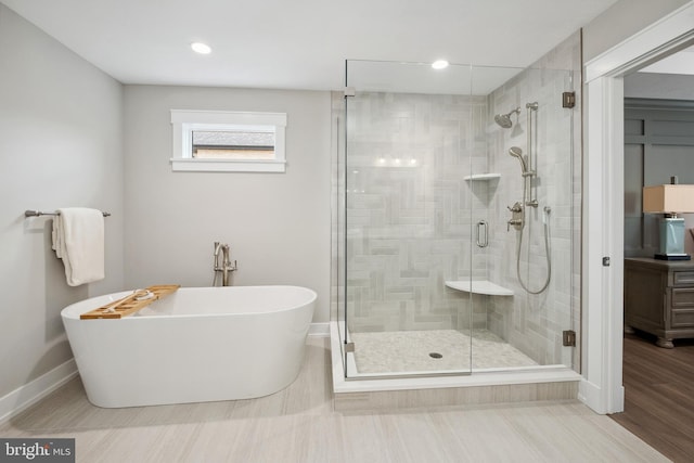 bathroom featuring shower with separate bathtub and hardwood / wood-style flooring