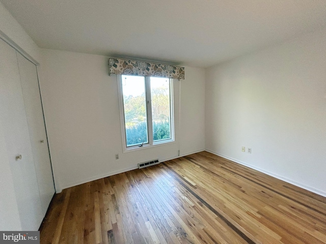 unfurnished bedroom featuring hardwood / wood-style floors and a closet