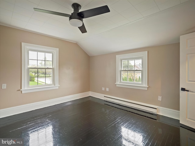 additional living space with a baseboard heating unit, lofted ceiling, a wealth of natural light, and dark hardwood / wood-style floors