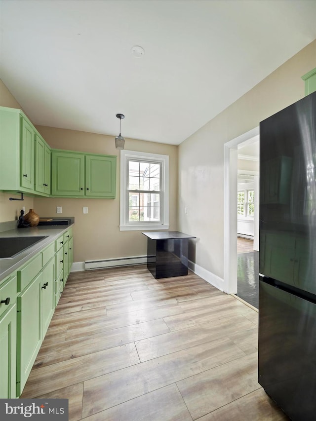 kitchen with black fridge, a baseboard radiator, green cabinets, and light hardwood / wood-style floors