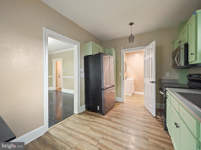 kitchen featuring pendant lighting, light hardwood / wood-style flooring, appliances with stainless steel finishes, green cabinets, and crown molding