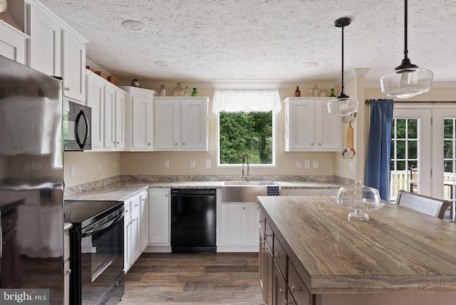 kitchen featuring pendant lighting, white cabinets, black appliances, and dark hardwood / wood-style floors