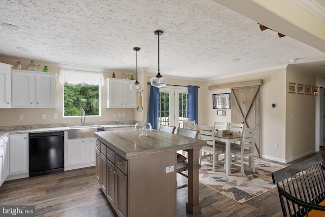 kitchen featuring a wealth of natural light, black dishwasher, a kitchen island, and white cabinets