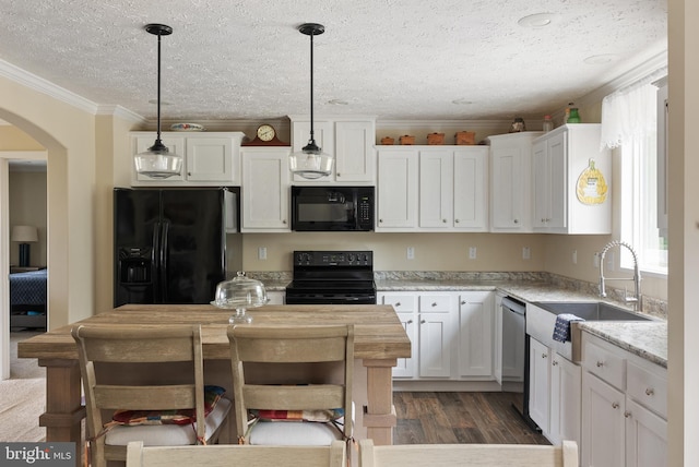 kitchen with light stone counters, dark hardwood / wood-style floors, white cabinetry, black appliances, and decorative light fixtures