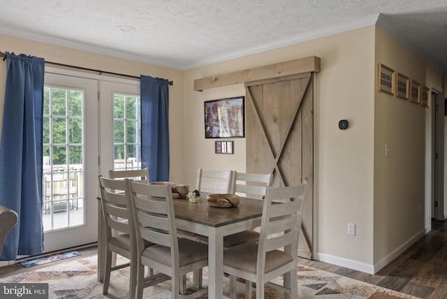 dining area with a textured ceiling, dark hardwood / wood-style floors, and a barn door