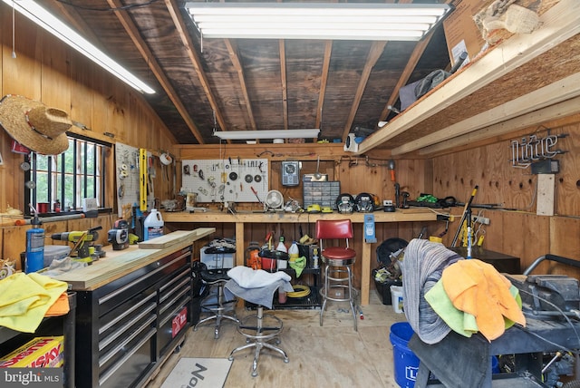 interior space featuring wooden walls, lofted ceiling, and a workshop area