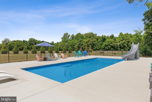 view of pool with a water slide and a patio area