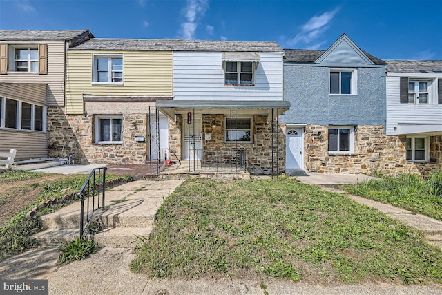 multi unit property with a porch and a front lawn