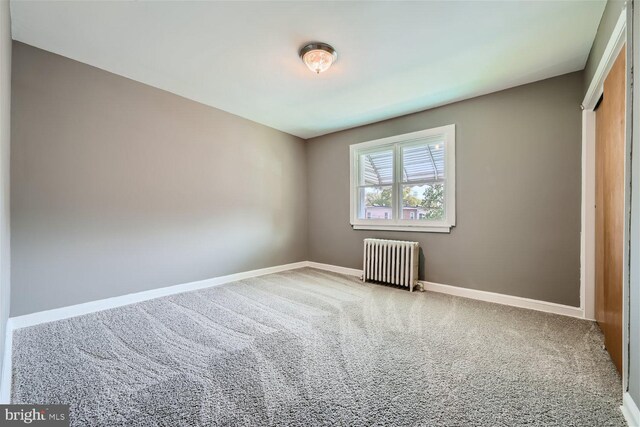 carpeted empty room featuring radiator