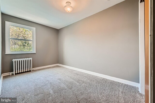 spare room with carpet flooring and radiator