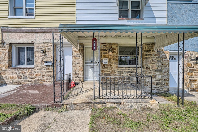 view of exterior entry featuring covered porch