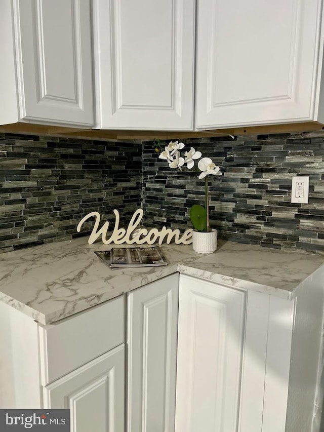 1128 Everett St, Camden, NJ 08104 - details with light stone countertops, white cabinetry, and decorative backsplash