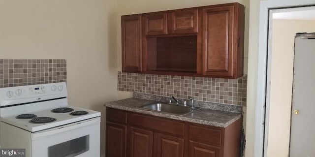 kitchen featuring backsplash, white electric range oven, and sink