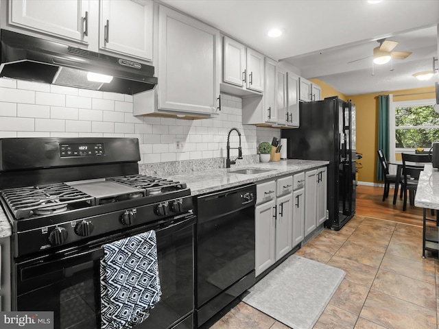 kitchen with sink, black appliances, tasteful backsplash, white cabinets, and ceiling fan