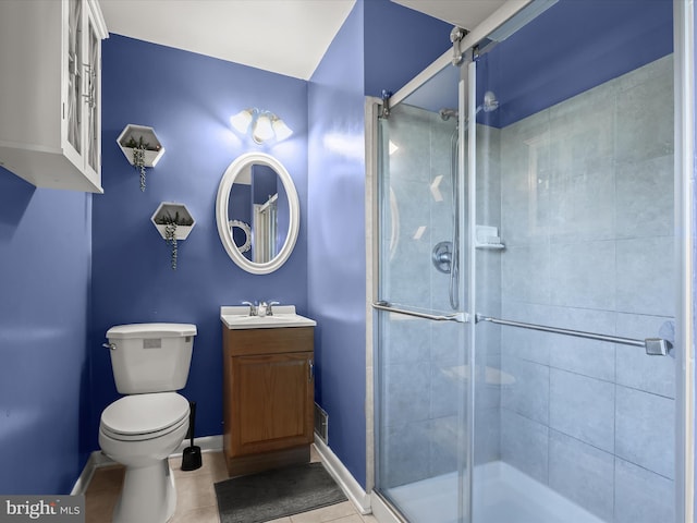 bathroom with vanity, toilet, tile patterned floors, and a shower with door