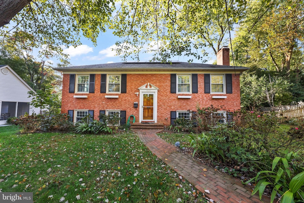 raised ranch featuring a front lawn