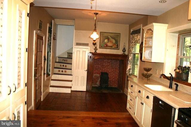 kitchen featuring black appliances, dark wood-type flooring, sink, white cabinetry, and hanging light fixtures