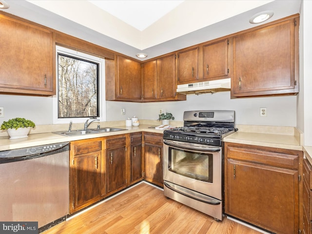 kitchen featuring appliances with stainless steel finishes, light hardwood / wood-style floors, and sink